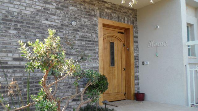 דלת הכניסה מעץ גושני מלא.