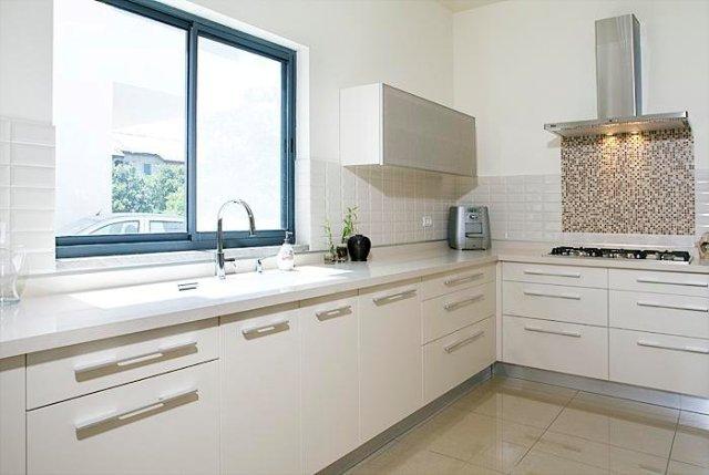 מבט אל הכיריים המחופות בפסיספס זכוכית כהה  