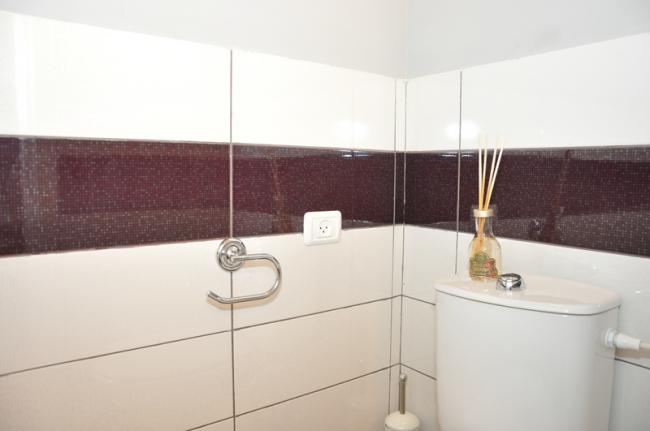 אריחים בסגול חציל-לבן לצד קיר אפור, כצבע המסעדה