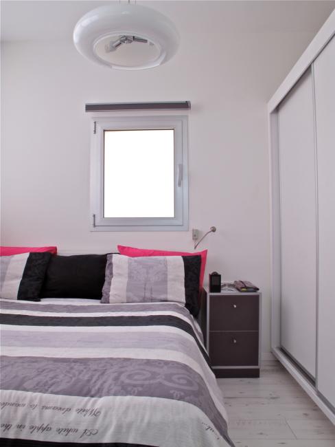 אזור השינה - מיטה זוגית וארון בגדים היוצר חציצה