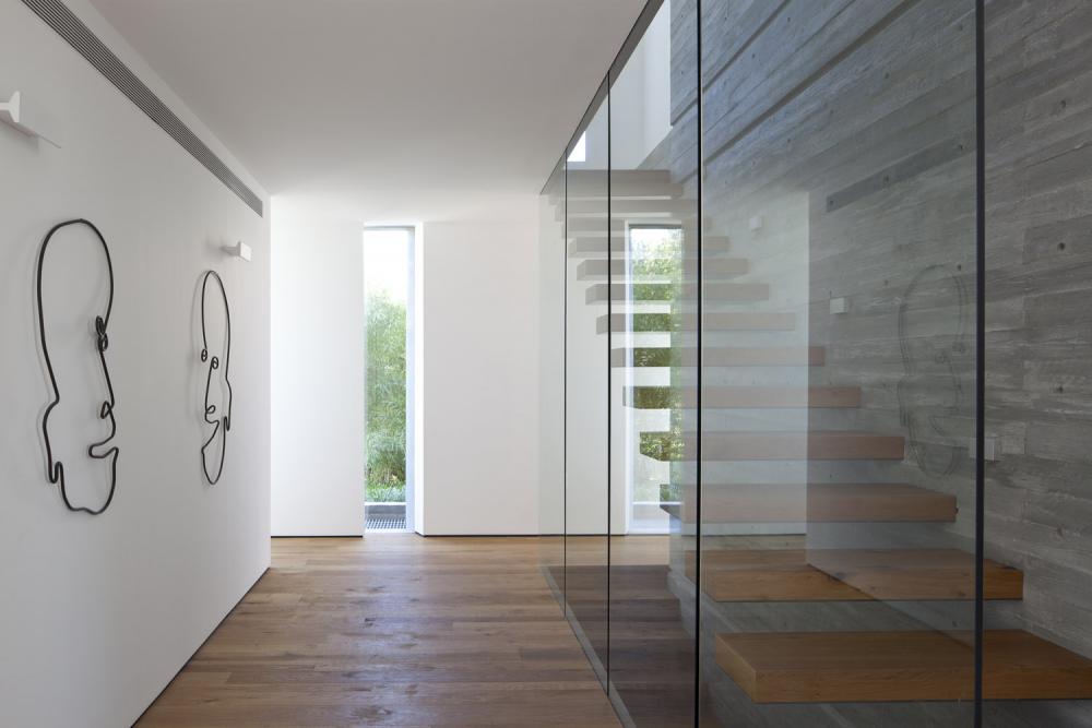 מדרגות עץ קונזוליות על קיר בטון חשוף