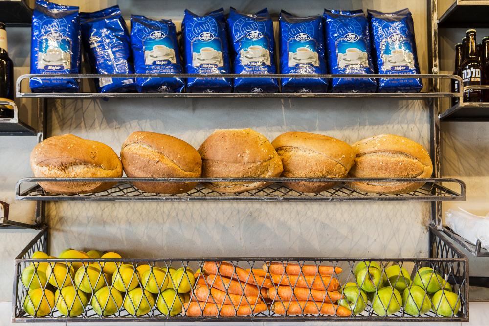 מדפי ברזל ורשת על גבי קיר בחיפוי שליכט בטון